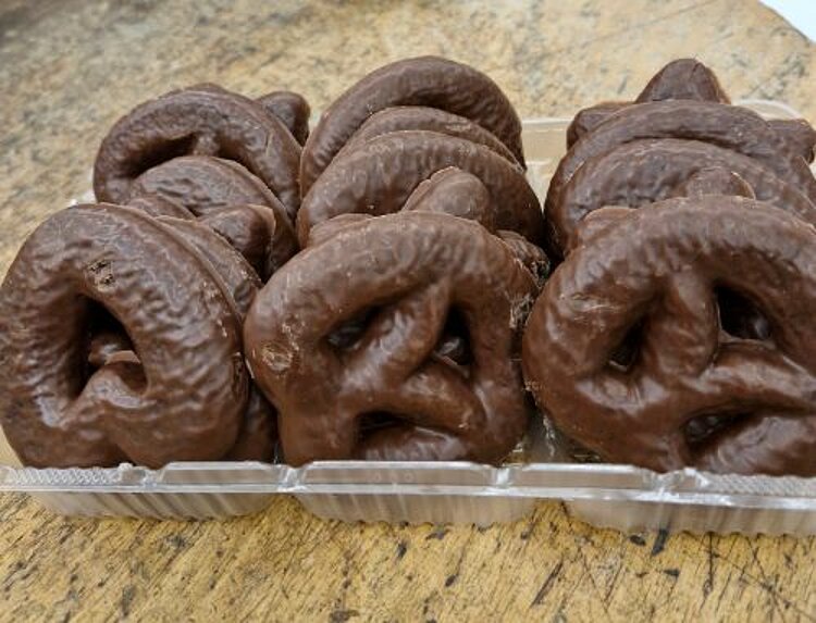 Weihnachtsfeier der Umschüler Schoko-Lebkuchenherzen und Brezeln in einer Verpackung stehen auf einem Holztisch.
